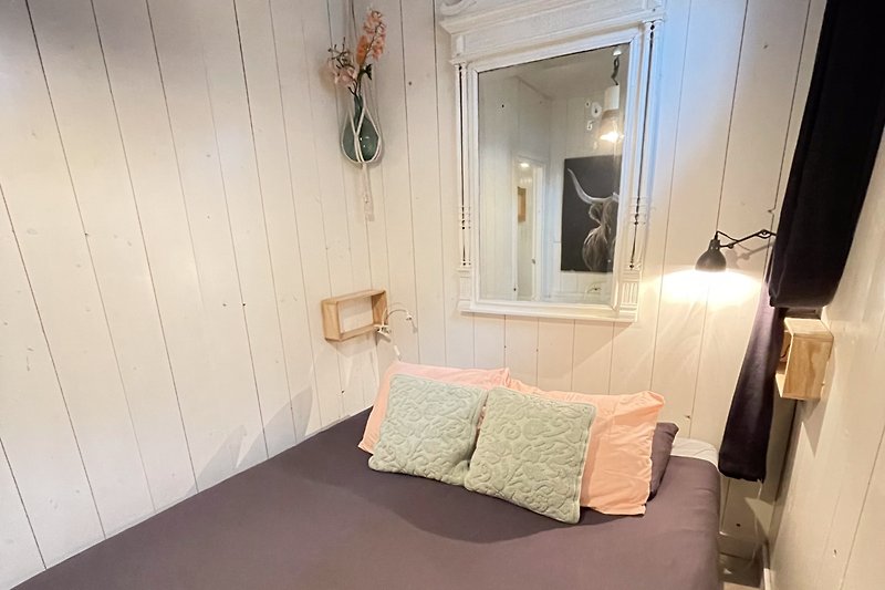 Gemütliches Schlafzimmer mit Holzbett und stilvoller Inneneinrichtung.