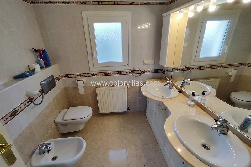 Schönes Badezimmer mit lila Vorhang, Spiegel und Waschbecken.