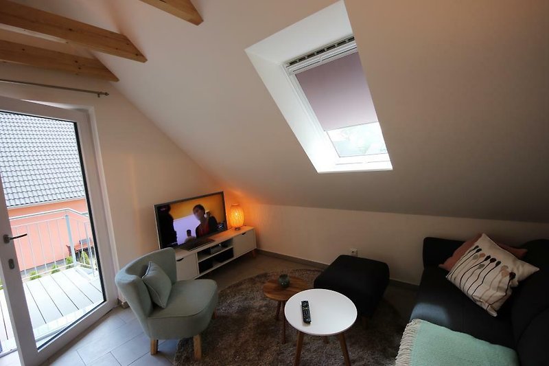 stilvolles Wohnzimmer mit TV und Dachschrägen