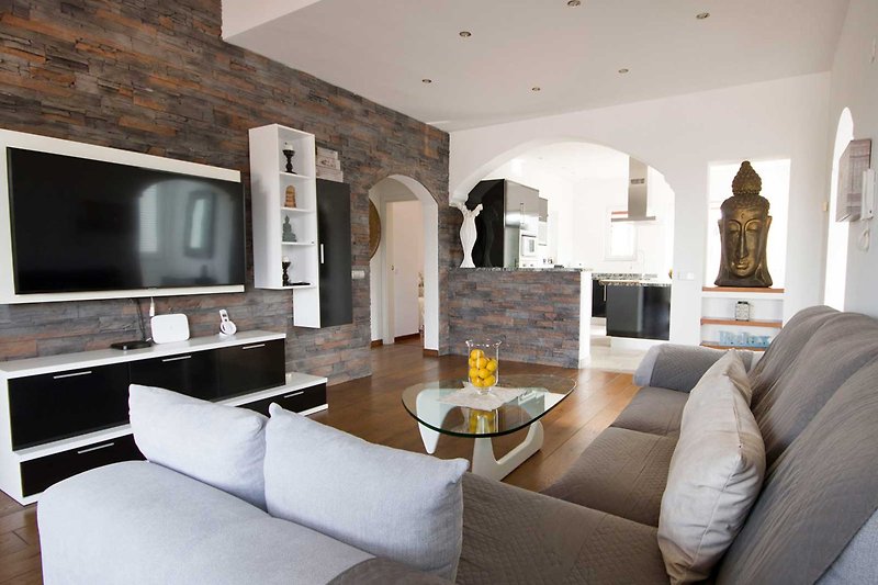 Modernes Wohnzimmer mit bequemer Couch, Tisch, Bilderrahmen und Dekoration. Gemütliche Atmosphäre.