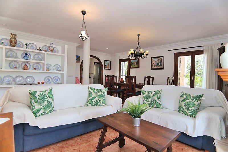 Gemütliches Wohnzimmer mit stilvoller Einrichtung und grünen Pflanzen.
