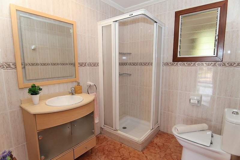 Modernes Badezimmer mit lila Akzenten, Dusche und stilvoller Einrichtung.