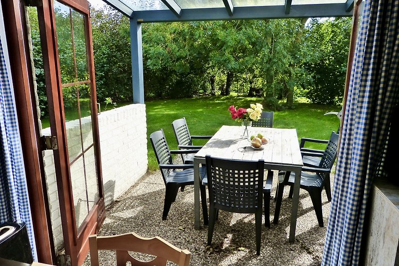 Gemütliche Terrasse mit Möbeln und Blick ins Grüne.