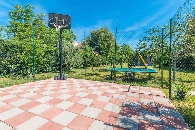 Unser Sportplatz mit Basketball, Tischtennis, Kinderschaukel und Trampolin