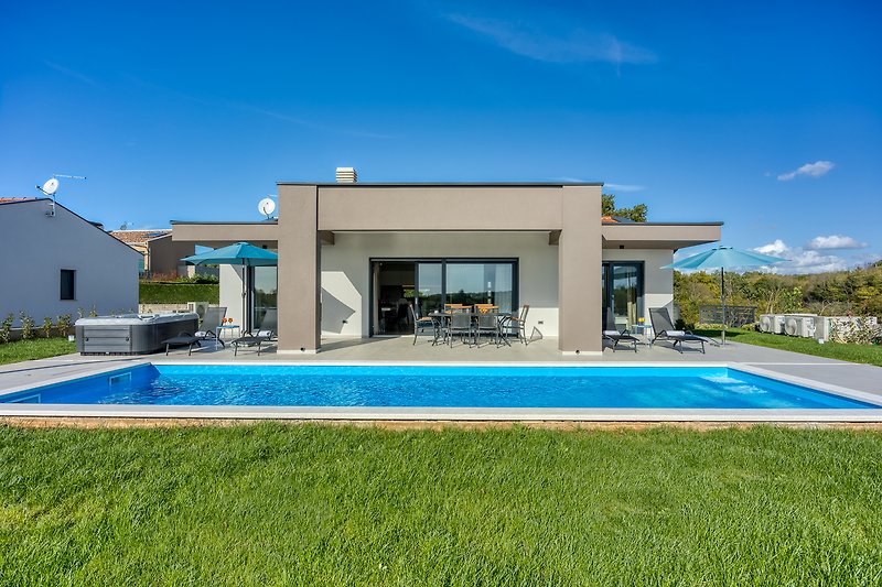A luxurious villa with a stunning swimming pool and beautiful landscaping.