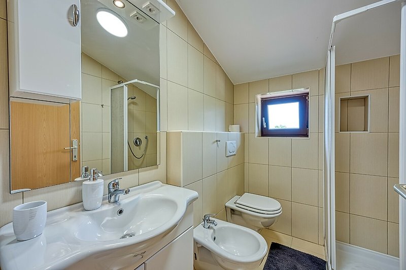 Badezimmer mit Spiegel, Waschbecken und lila Badezimmerschrank.