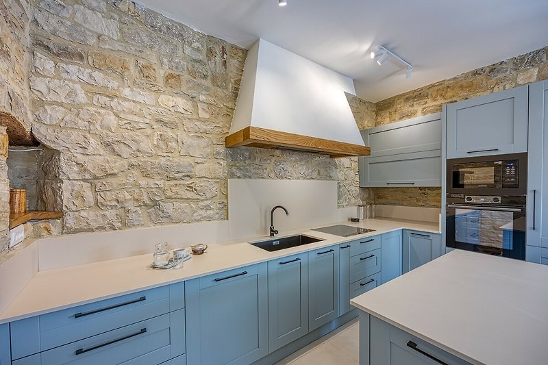 Moderne Küche mit Holzschrank, Granitarbeitsplatte und Edelstahlspüle.