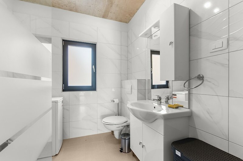 Schönes Badezimmer mit lila Akzenten und modernem Waschbecken.