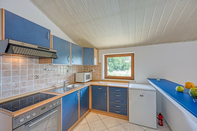 Moderne Küche mit Holzschränken, Arbeitsplatte und Spüle.