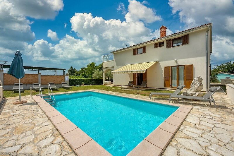 Schwimmendes Ferienhaus mit Pool, umgeben von Wasser, Pflanzen und blauem Himmel.