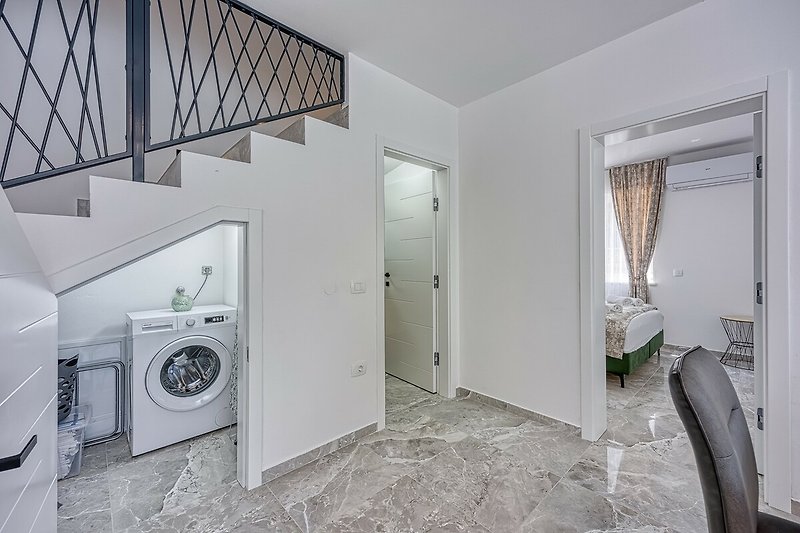 A well-lit laundry room with modern appliances and stylish design.