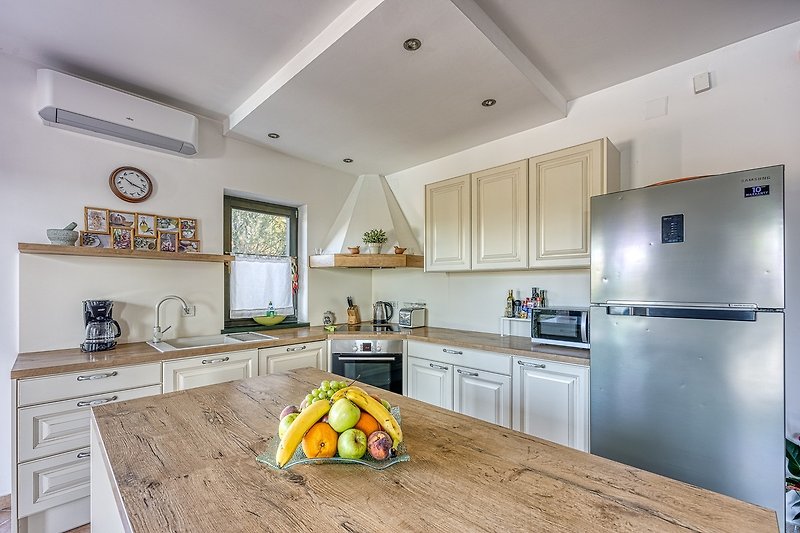 Gemütliche Küche mit Holzmöbeln, grauem Boden und stilvollem Licht.