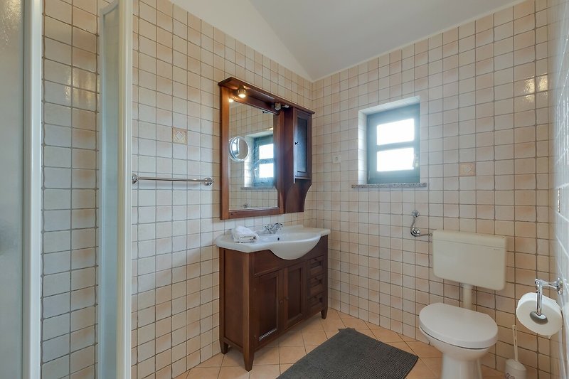 Schönes Badezimmer mit stilvollem Waschbecken und Spiegel.