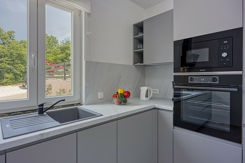 Stylish kitchen with modern appliances, sleek countertops, and a beautiful view.
