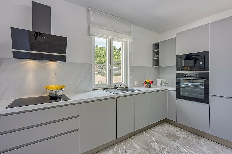 Stylish kitchen with modern appliances, sleek countertops, and a beautiful view.