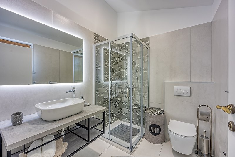Modernes Badezimmer mit lila Akzenten, Spiegel und Dusche.