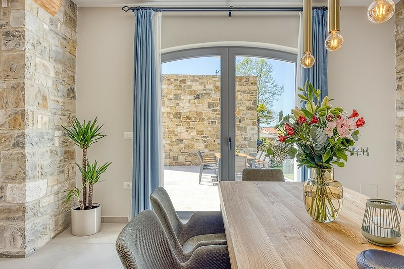 Modernes Wohnzimmer mit Holzmöbeln, Pflanzen und Fensterblick.