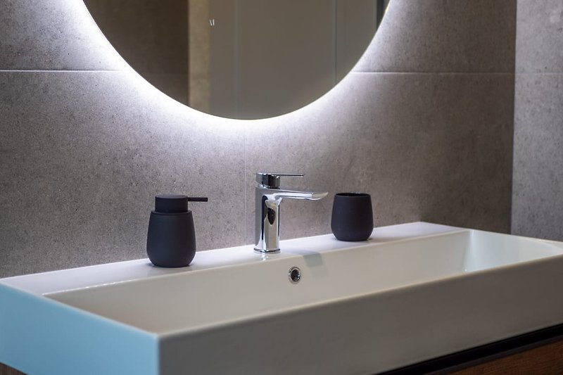 Stylish bathroom with a modern sink, elegant mirror, and sleek fixtures.