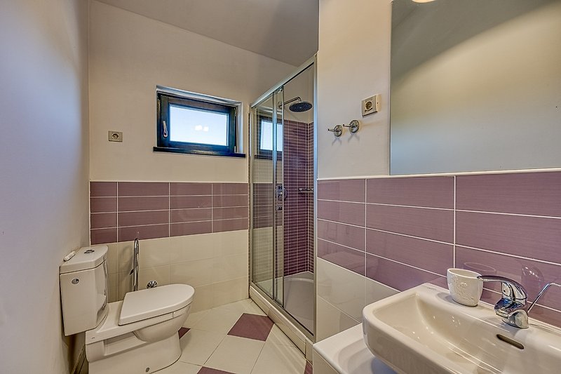 Schönes Badezimmer mit lila Beleuchtung und modernem Design.
