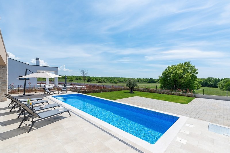 Schöne Ferienwohnung mit Pool, Garten und Meerblick. Entspannen Sie auf der Terrasse mit Sonnenliegen und genießen Sie die Aussicht.