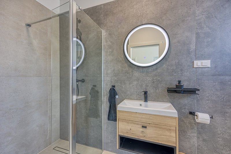 Modernes Badezimmer mit elegantem Design und lila Akzenten.