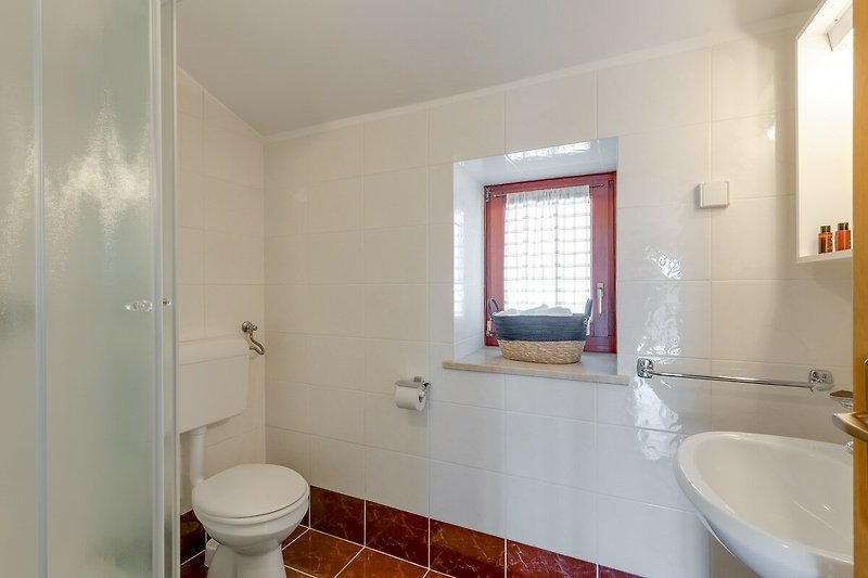 Schönes Badezimmer mit lila Akzenten und Holzboden.