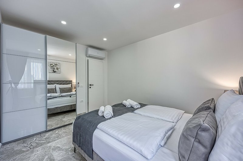 Experience ultimate comfort in this stylish bedroom with beautiful furniture and soothing grey tones.