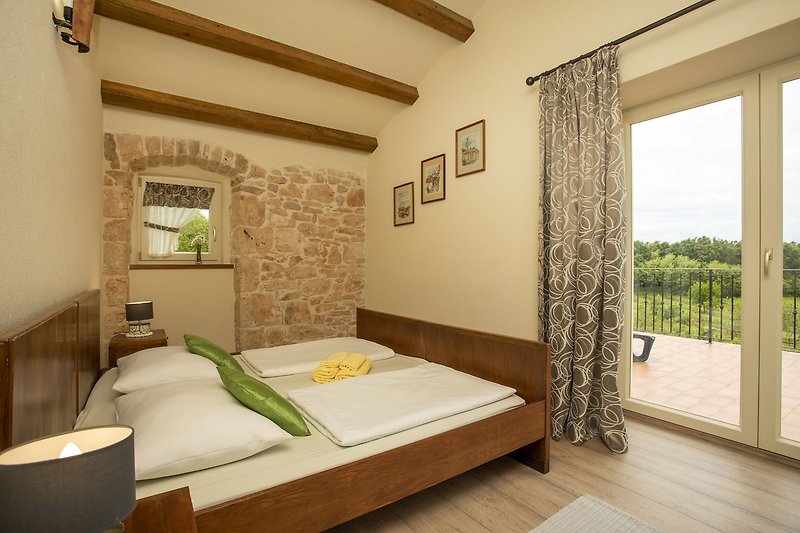 Stilvolles Schlafzimmer mit Holzmöbeln, gemütlichem Bett und eleganten Vorhängen.