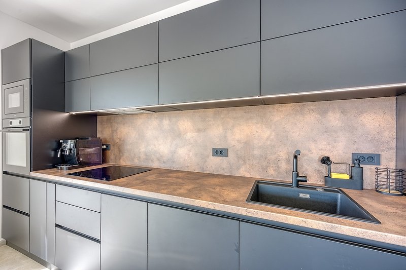 Moderne Küche mit Granitarbeitsplatte, Holzschränken und Edelstahlspüle.