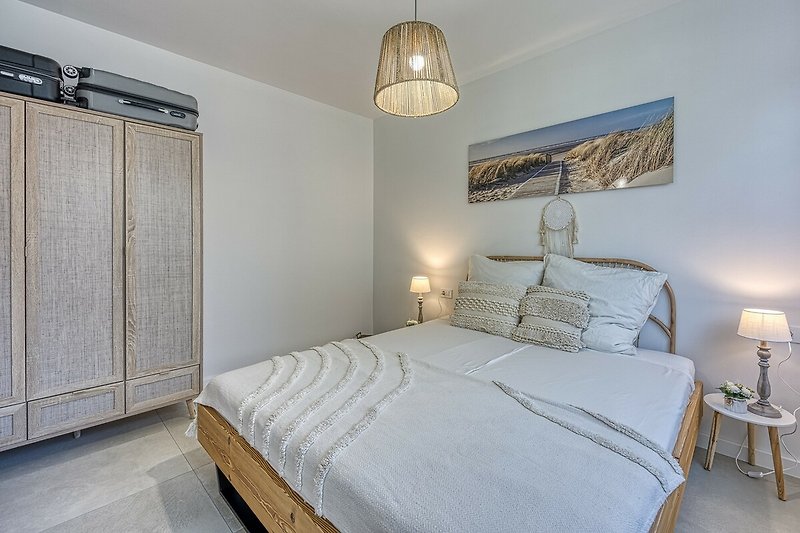 Stilvolles Schlafzimmer mit gemütlichem Bett und elegantem Lampenschirm.
