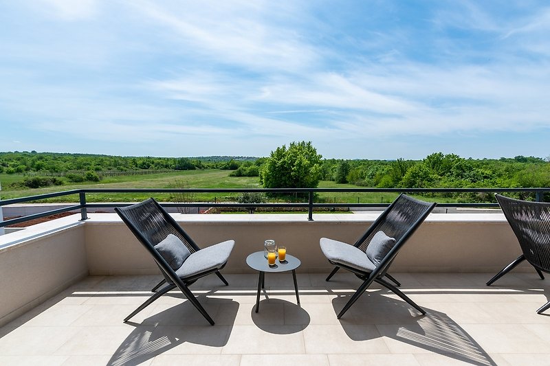 Schöne Terrasse mit Gartenmöbeln und Blick auf die Landschaft.