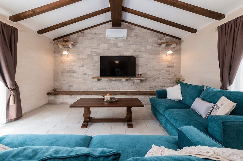Gemütliche Einrichtung mit blauem Sofa und Holzmöbeln.