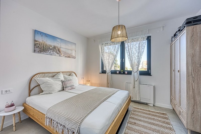 Gemütliches Schlafzimmer mit stilvollem Bett und elegantem Lampenschirm.