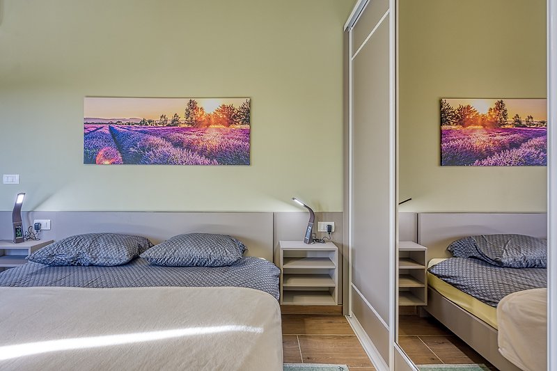 Elegantes Schlafzimmer mit lila Akzenten und gemütlichem Bett.