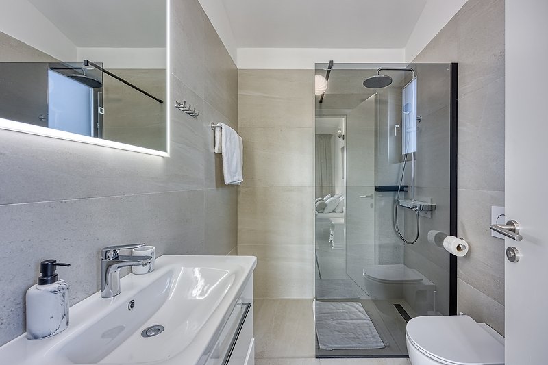 Modern bathroom with a sleek sink, mirror, and stylish fixtures.