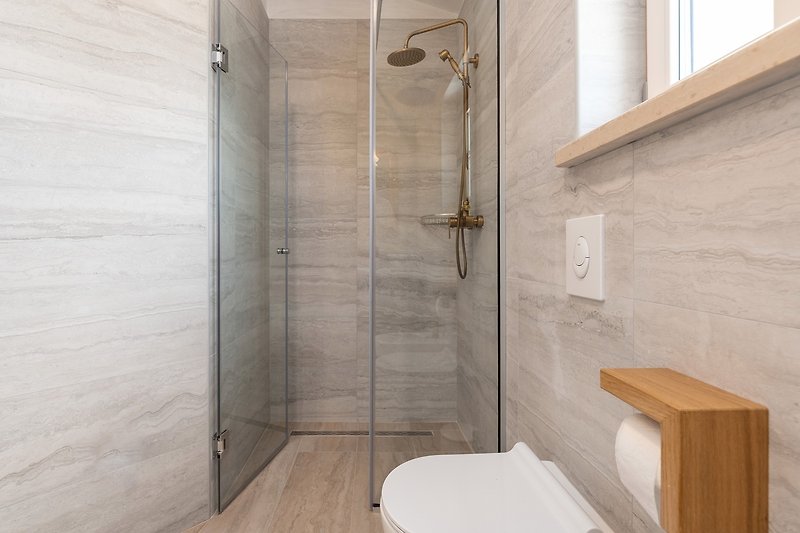 Moderne Dusche mit Glaswand und Holzboden.