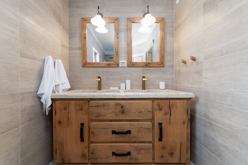 Einladendes Badezimmer mit braunem Schrank, Holzmöbeln und stilvoller Beleuchtung.