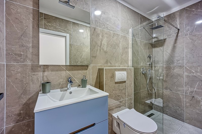 A modern bathroom with a stylish mirror, tap, and plumbing fixtures.
