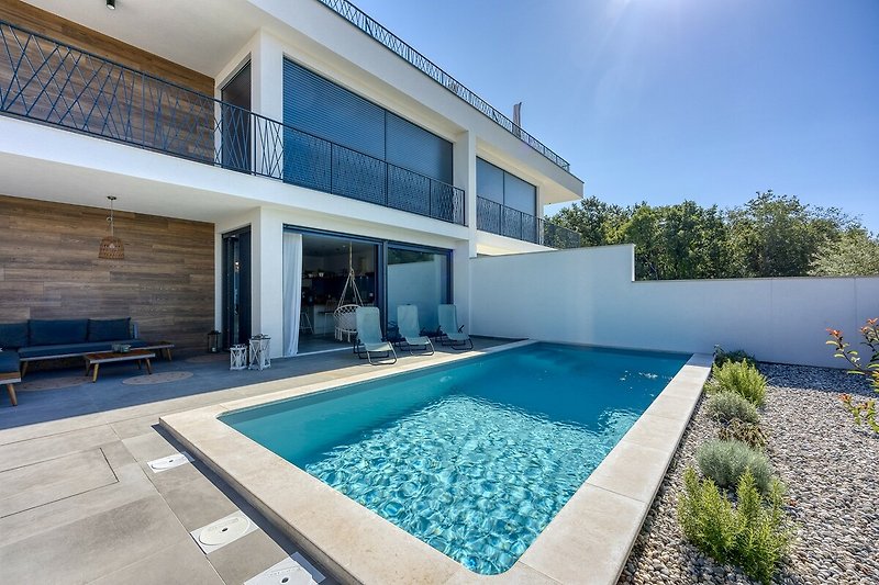 Moderne Ferienwohnung mit Pool, blauem Himmel und stilvollem Design.
