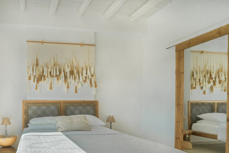 Gemütliches Schlafzimmer mit Holzmöbeln und Fensterbehang.