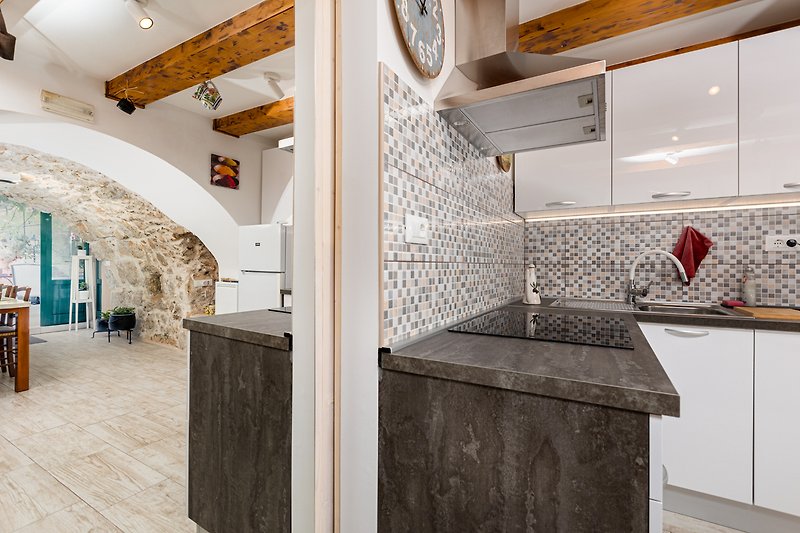 Stilvolle Küche mit Holzboden, Granit-Arbeitsplatte und modernen Geräten.