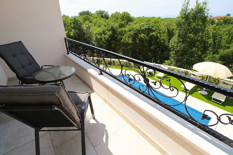 Balkon mit Blick am Pool und Garten