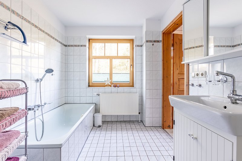 Schönes Badezimmer mit moderner Ausstattung und lila Akzenten.