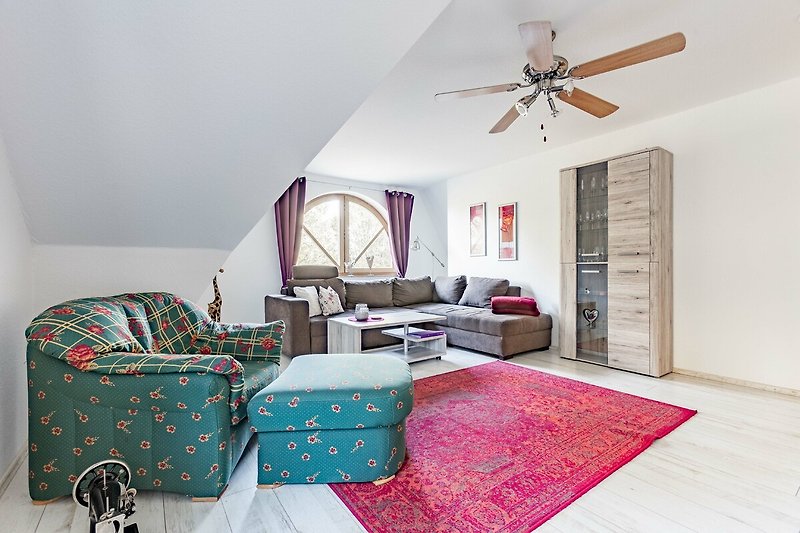Gemütliches Wohnzimmer mit bequemer Couch, Holzmöbeln und lila Akzenten.