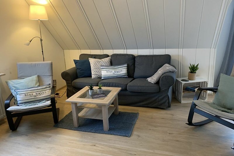 Modernes Wohnzimmer mit bequemer Couch, Tisch und Lampen. Gemütliche Atmosphäre.