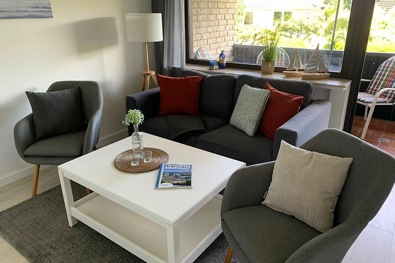 Modernes Wohnzimmer mit stilvoller Einrichtung und großem Fenster. Gemütliche Couch und Designer-Möbel.