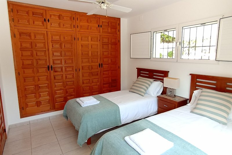 Schlafzimmer mit Holzbett und gemütlicher Einrichtung.