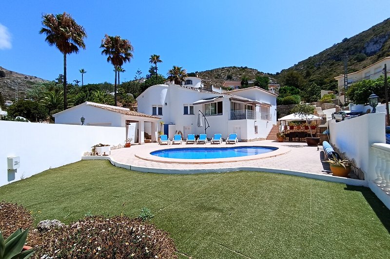 Luxuriöse Villa mit Pool, Palmen und Meerblick.