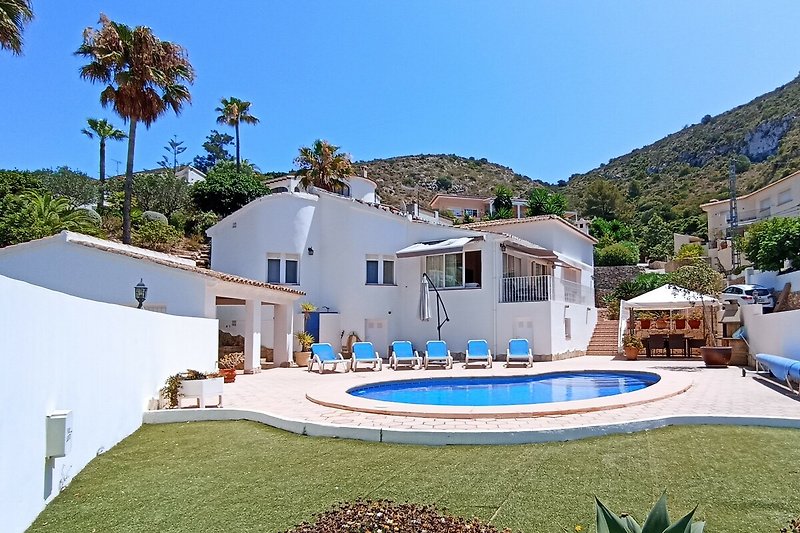 Luxuriöse Villa mit Pool, Palmen und Meerblick.