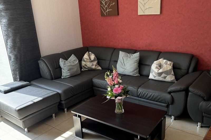 Wohnzimmer mit Schlafsofa, Couchtisch und stilvoller Dekoration.